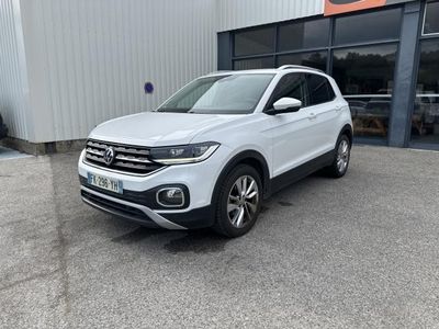 a white volkswagen suv parked in front of a building