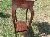 une petite table avec une étagère posée dessus, dans l'herbe