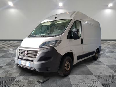 une camionnette blanche garée sur un sol en damier