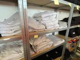 a lot of clothes on the shelves in the room
