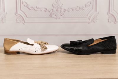 two pairs of black and white shoes with tassels on them