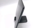 a laptop computer sitting on a stand on a white surface