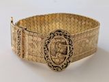 une photo d'un bracelet en or orné d'un motif élaboré