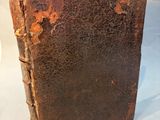 an old book sitting on top of a white table covered in rust