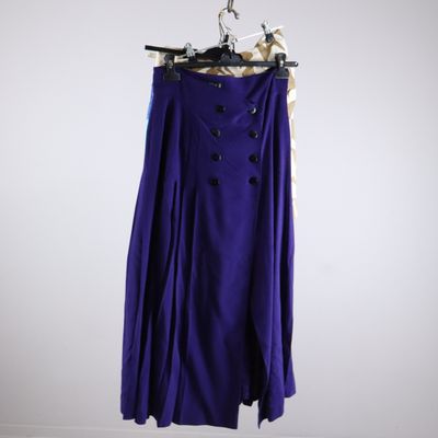 a purple skirt hanging on a hanger against a white wall