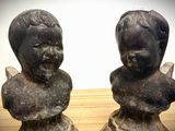 two statues of a boy and a girl sitting on a table