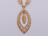 an image of a gold necklace with a leaf design on it