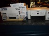 two printers sitting on a counter next to each other