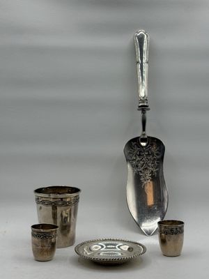 a silver spoon and cups sitting next to each other