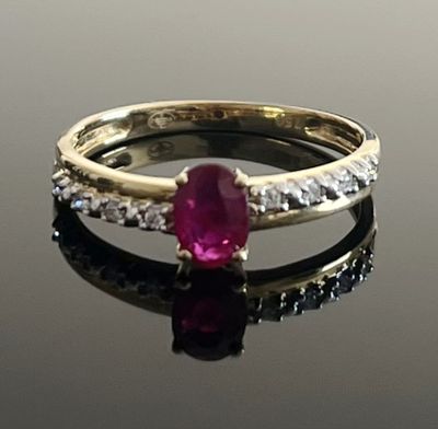 ruby and diamond ring on a reflective surface with reflection