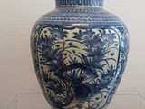 a blue and white vase on display in a glass case