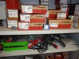 many boxes of wires and other electrical equipment on a shelf