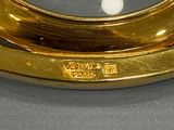 a gold clock sitting on top of a black table