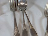 a lot of silver spoons and forks on the table