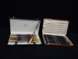 two sets of knives in a case on a table