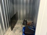 a small storage room with a laptop on the floor