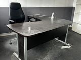 a desk with a chair and a book shelf in the corner
