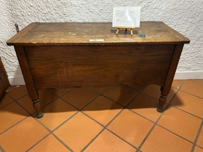 a small wooden table with a sign on top of it