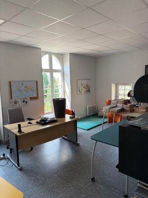 une pièce équipée d'un bureau, de chaises et d'une télévision