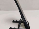 a black tablet on a stand on a white table