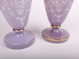 pair of purple vases sitting on top of each other on a white surface