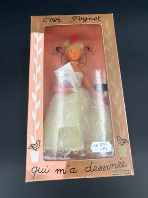 une poupée dans une boîte posée sur une table