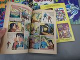 a person holding a comic book open on a table