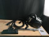 a black camera and a vacuum on a wooden table