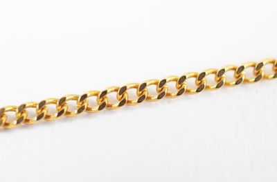 a close up of a gold chain on a white surface