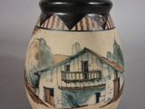 a vase with a picture of a house on it
