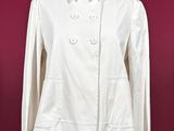 a white jacket on a mannequin stand against a red wall