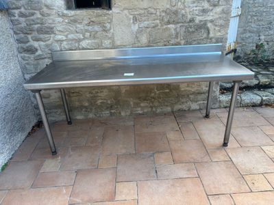 a stainless steel table on a tiled floor