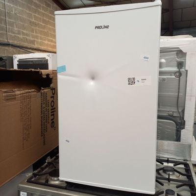 un réfrigérateur blanc posé sur une cuisinière dans une pièce