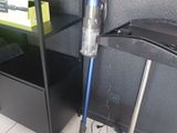 a vacuum that is on the floor next to a shelf