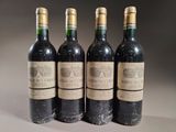 four bottles of wine are lined up on a table