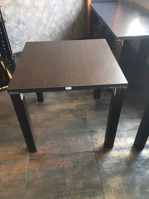 des tables et des chaises dans une pièce, avec un mur en arrière-plan