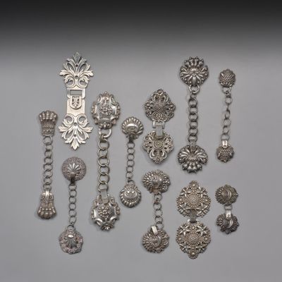 plusieurs bijoux en argent posés sur une surface grise