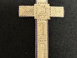 gold and purple cross on a black surface