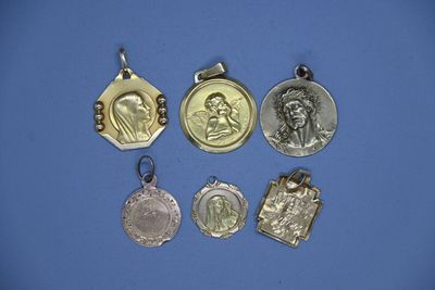 quatre médailles d'argent de tailles et de formes variées sur fond bleu