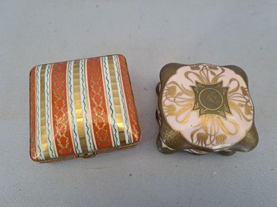 Deux petites boîtes sont posées l'une à côté de l'autre sur une table.