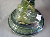a green vase with a dog on it on a table