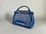 a blue leather handbag on a white background