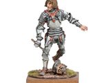 the figurine is standing on a wooden base with a sword