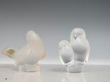 deux figurines d'oiseaux posées l'une à côté de l'autre sur une table