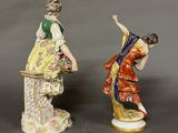 two figurines of a woman and a man on a pedestal