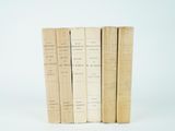 several old books are stacked on top of each other on a white surface