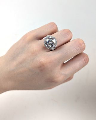 la main d'une femme tenant une bague sertie d'un diamant