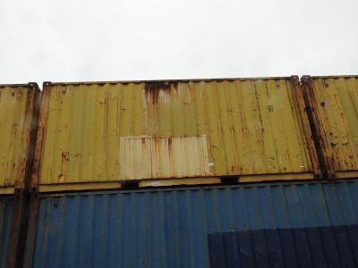un conteneur jaune et bleu posé contre le mur d'un immeuble