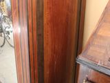 a tall wooden cabinet with a mirror on top of it