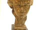 statue représentant la tête d'une femme, posée sur un socle en bois